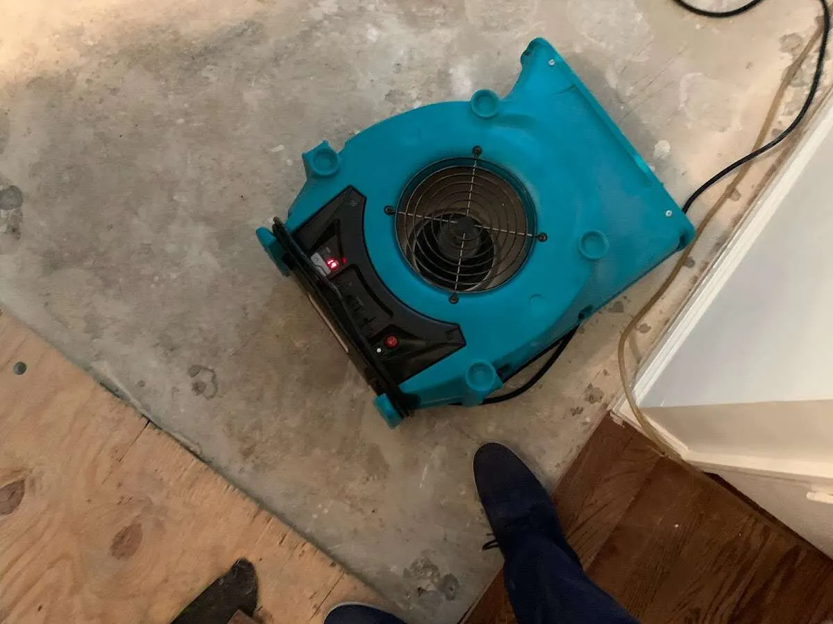 Air mover drying subfloor during Commercial Water Damage Restoration in Ayer